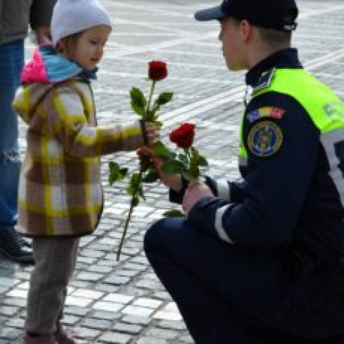 Flori și zâmbete oferite de polițiști, jandarmi și pompieri brașoveni de Ziua Femeii în Piața Sfatului, cu recunoștință și admirare